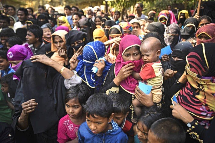 In 2017, Rohingya refugees from Myanmar waiting for food aid in Kutupalong refugee camp near Cox's Bazar, Bangladesh. (Photo by Hafiz Johari, Shutterstock.com)
