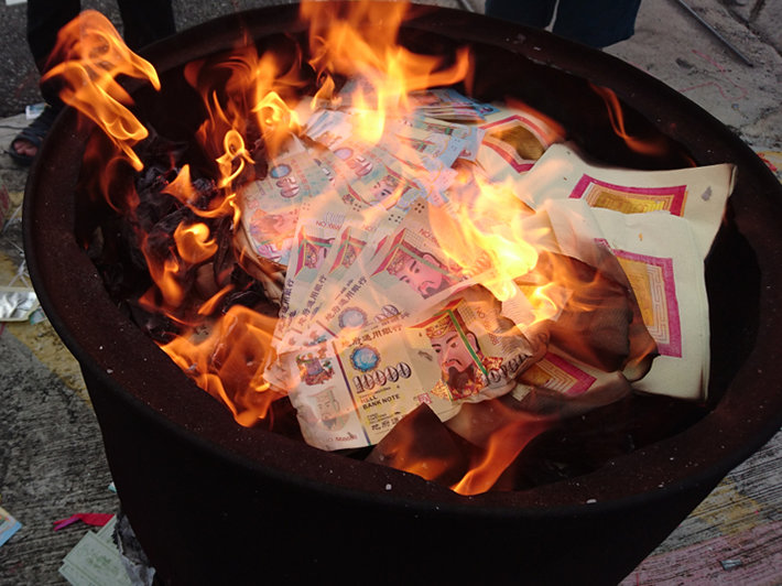 Burning “ghost money“ for the ancestors. (Photo buy PixelRed, Shutterstock.com)